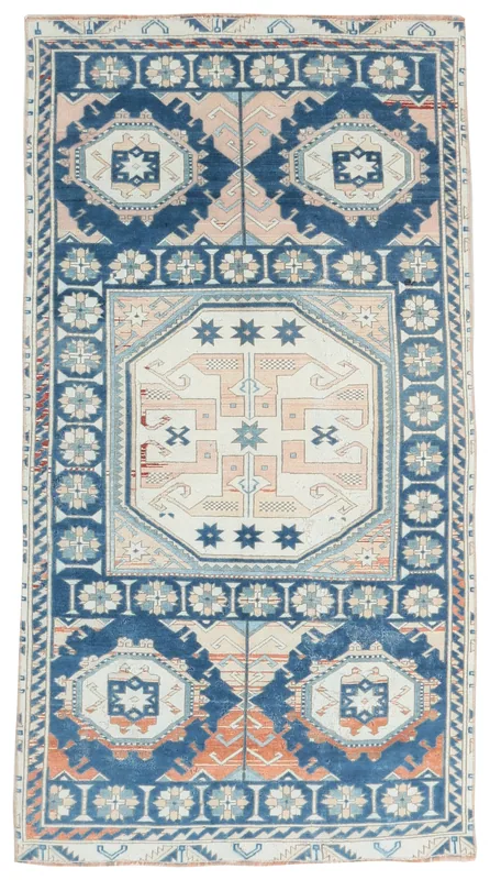 Full overhead view of the vintage Anatolian rug with blue, ivory, and rust geometric patterns