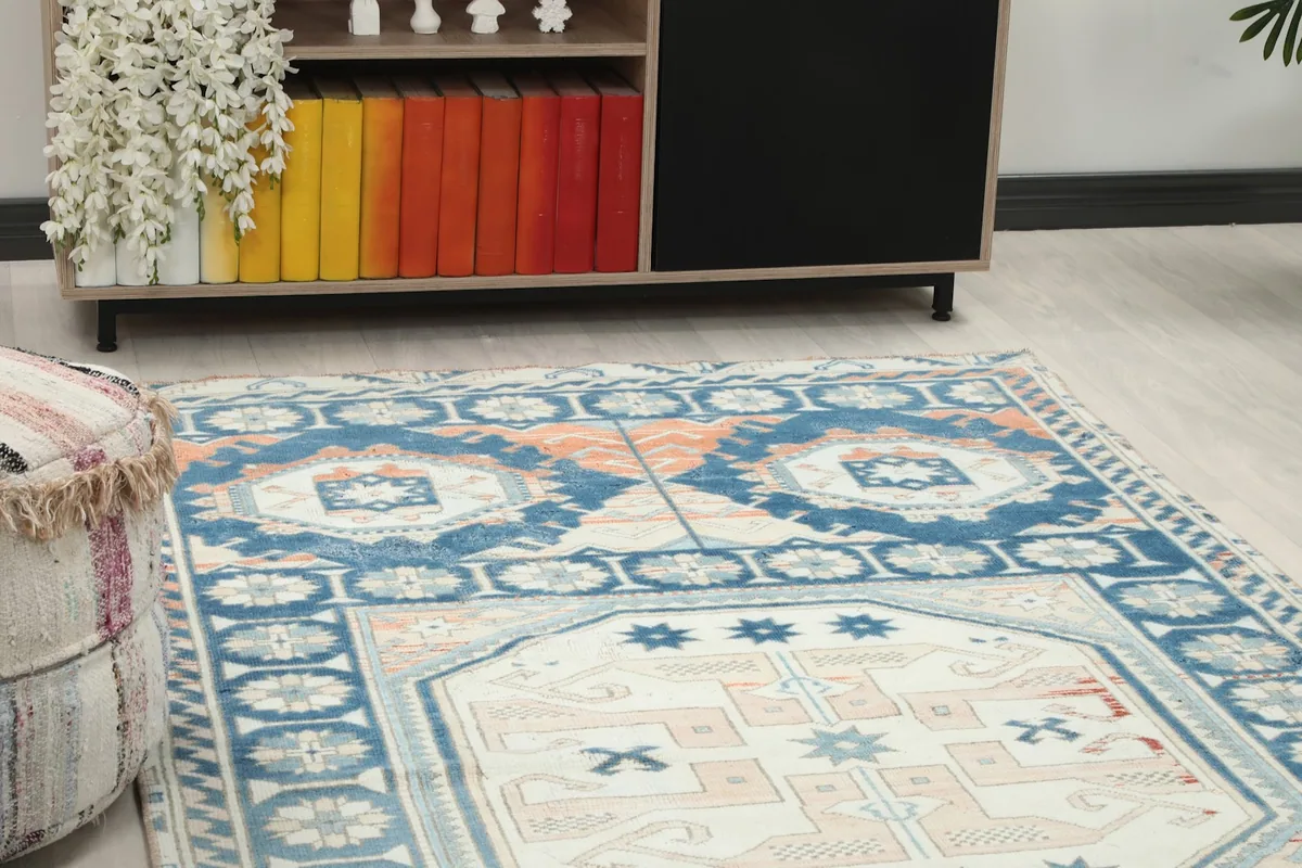 Close-up of the rug's central ivory medallion and surrounding blue and rust patterns