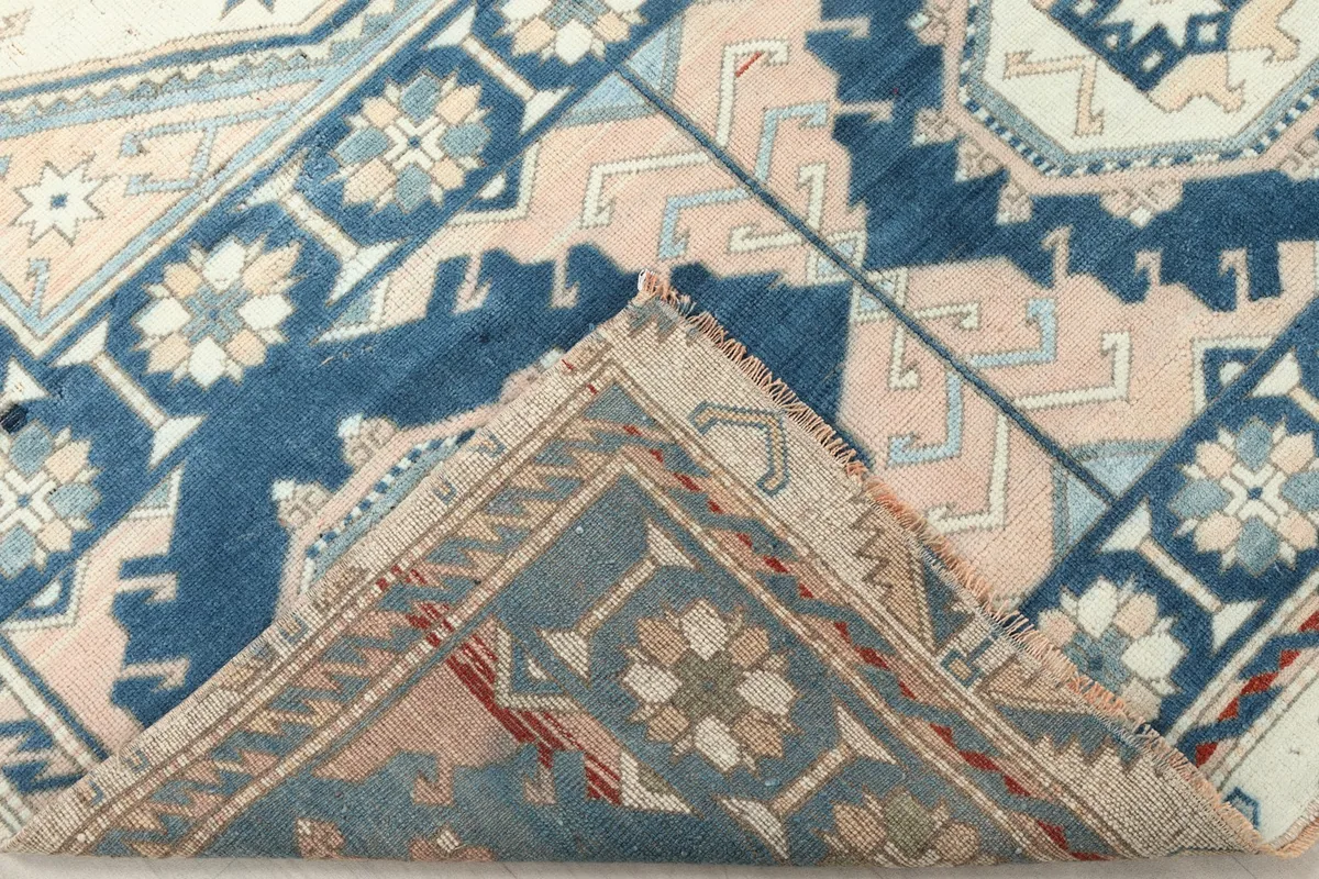 Folded corner of the rug revealing the reverse side of the hand-knotted wool and cotton foundation