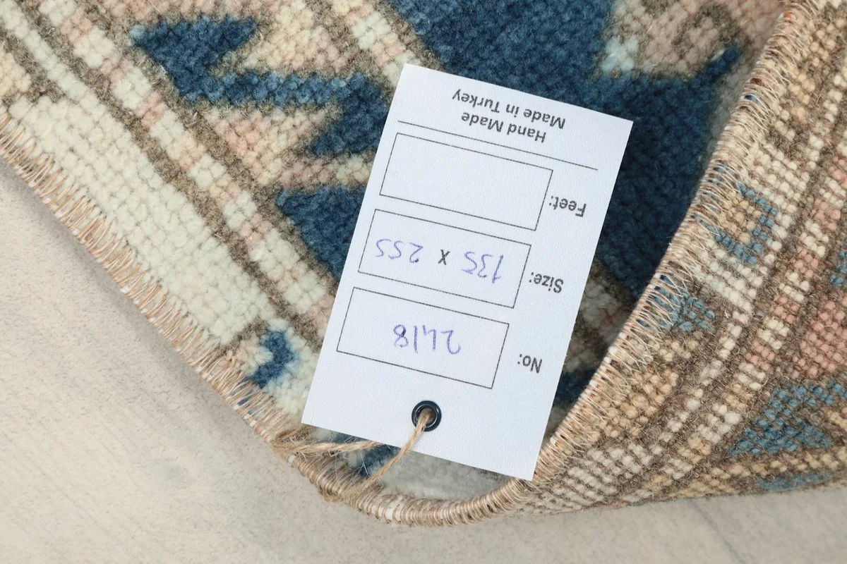 Label showing the rug's dimensions in centimeters and feet, confirming its hand-made origin