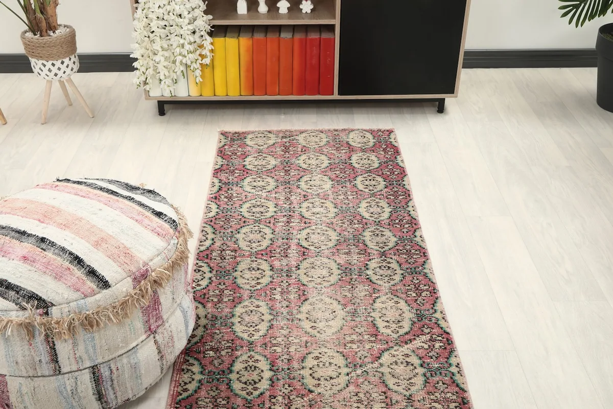 Overhead view of the rose and beige runner rug in a room setting, positioned in a hallway.