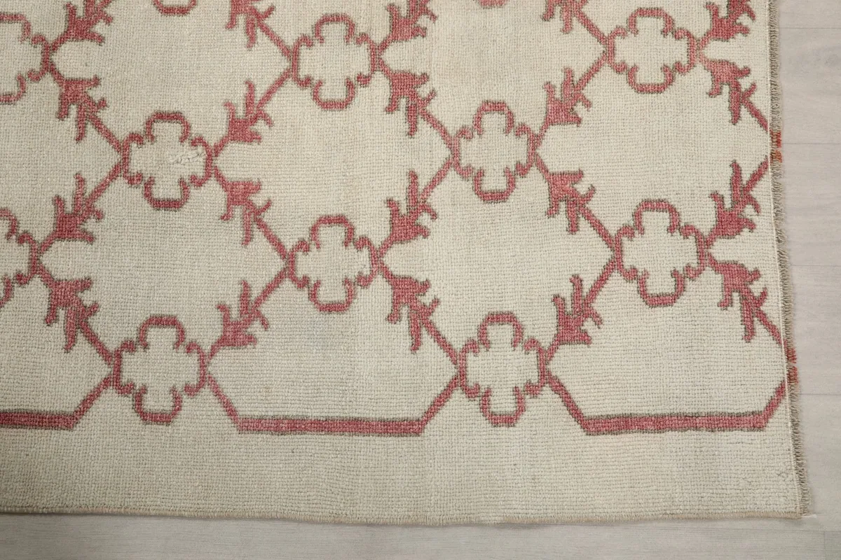Detailed view of the rose border design and corner of the vintage rug
