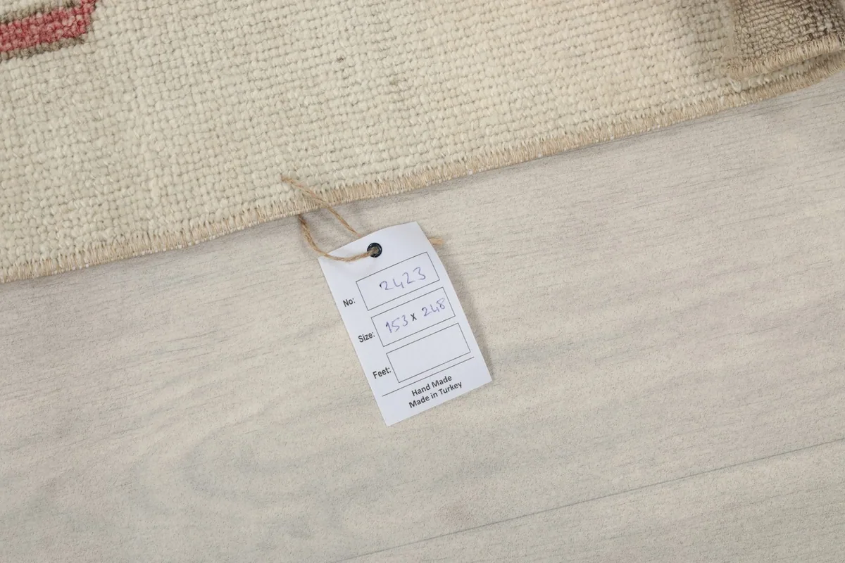 Product tag attached to the rug, showing size and hand-made origin