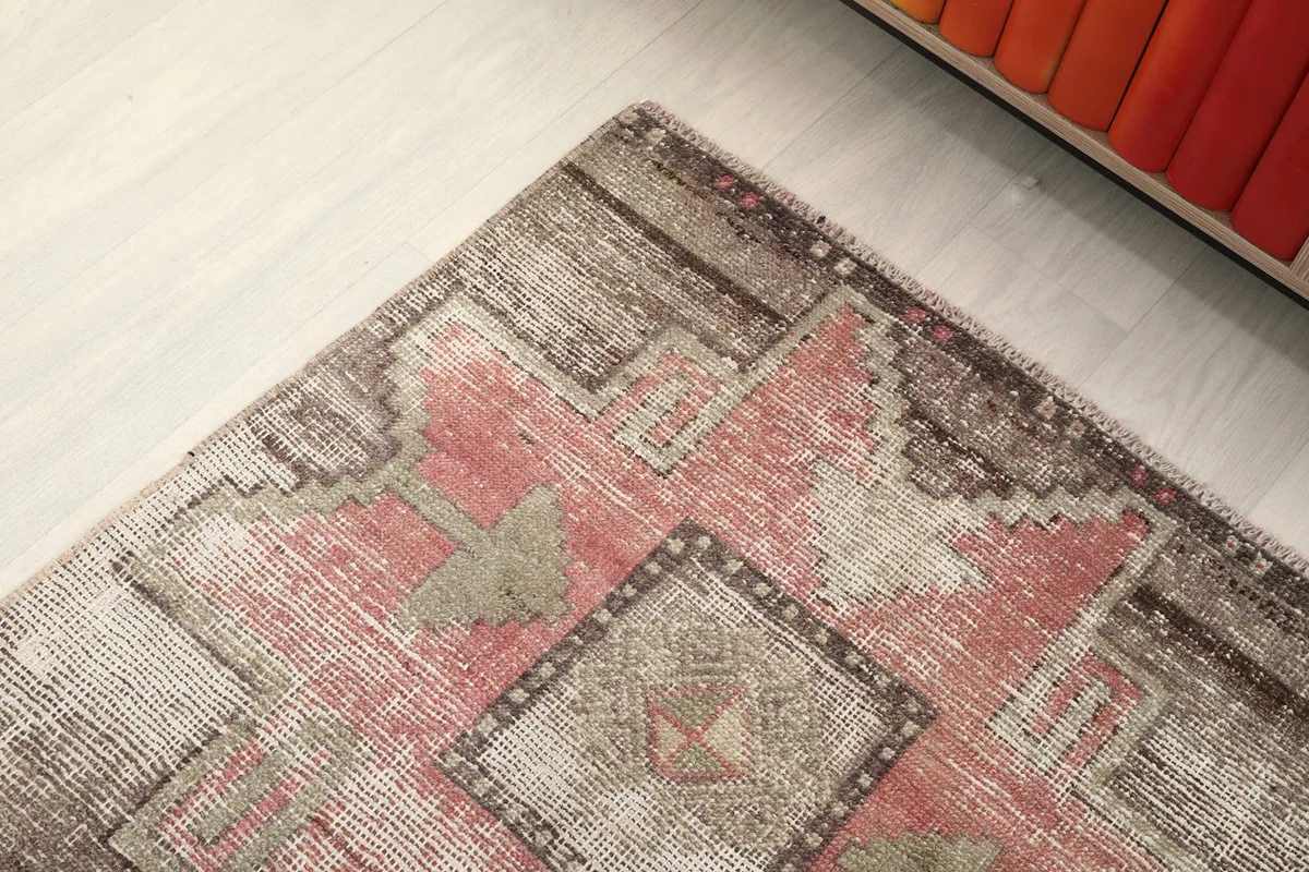 Angled detail shot of the rug's pattern, including the subtle color shifts and wear