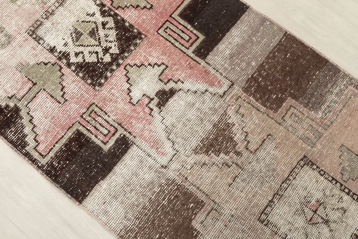 Close-up of the rug's central design elements, highlighting the pink and brown color variations