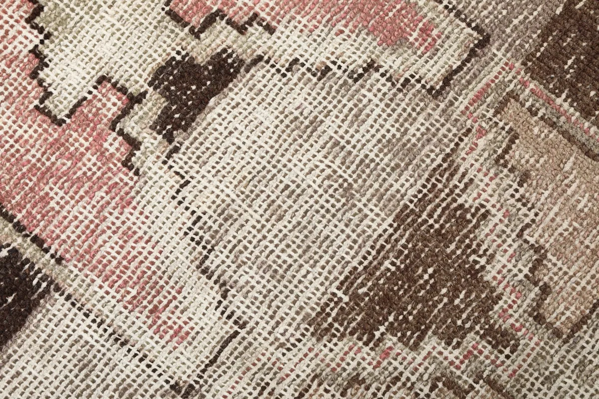 Extreme close-up showing the low wool pile and hand-knotted texture of the vintage rug
