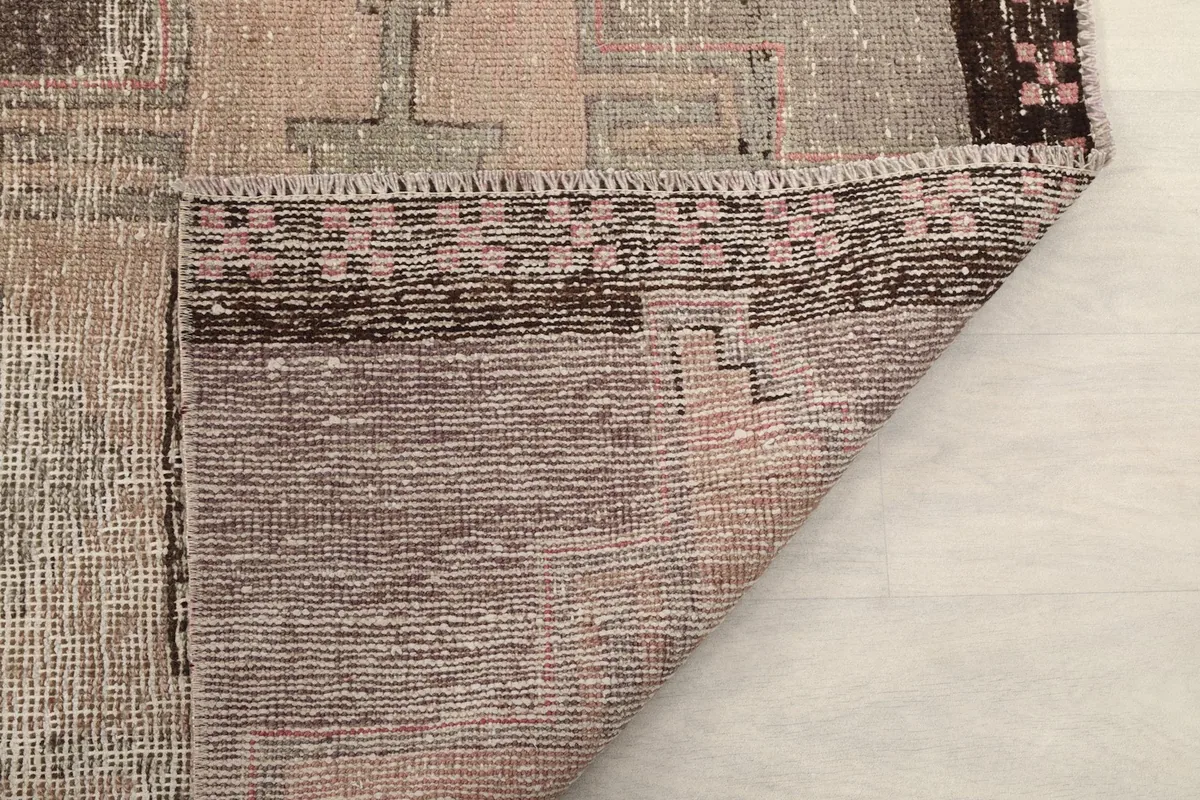 Underside corner of the runner rug, revealing the woven cotton foundation and hand-knotted structure