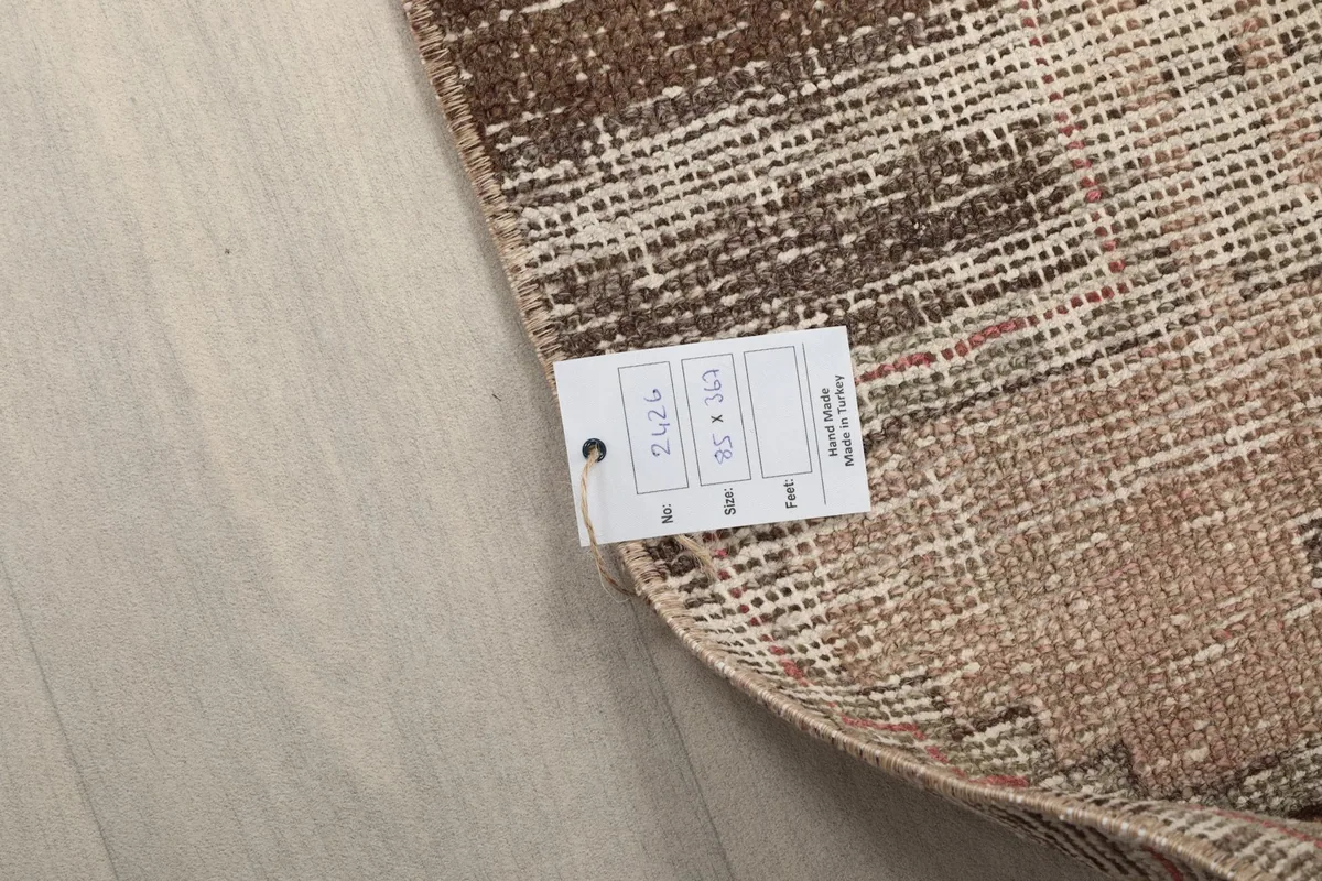 Close-up of the rug's back with a product tag showing its dimensions in feet/inches and centimeters