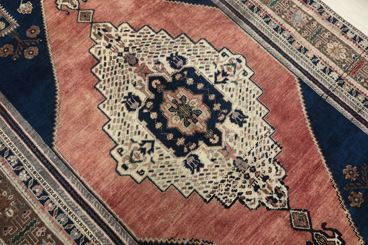 Close-up of the central rust field and navy diamond with the ivory medallion design