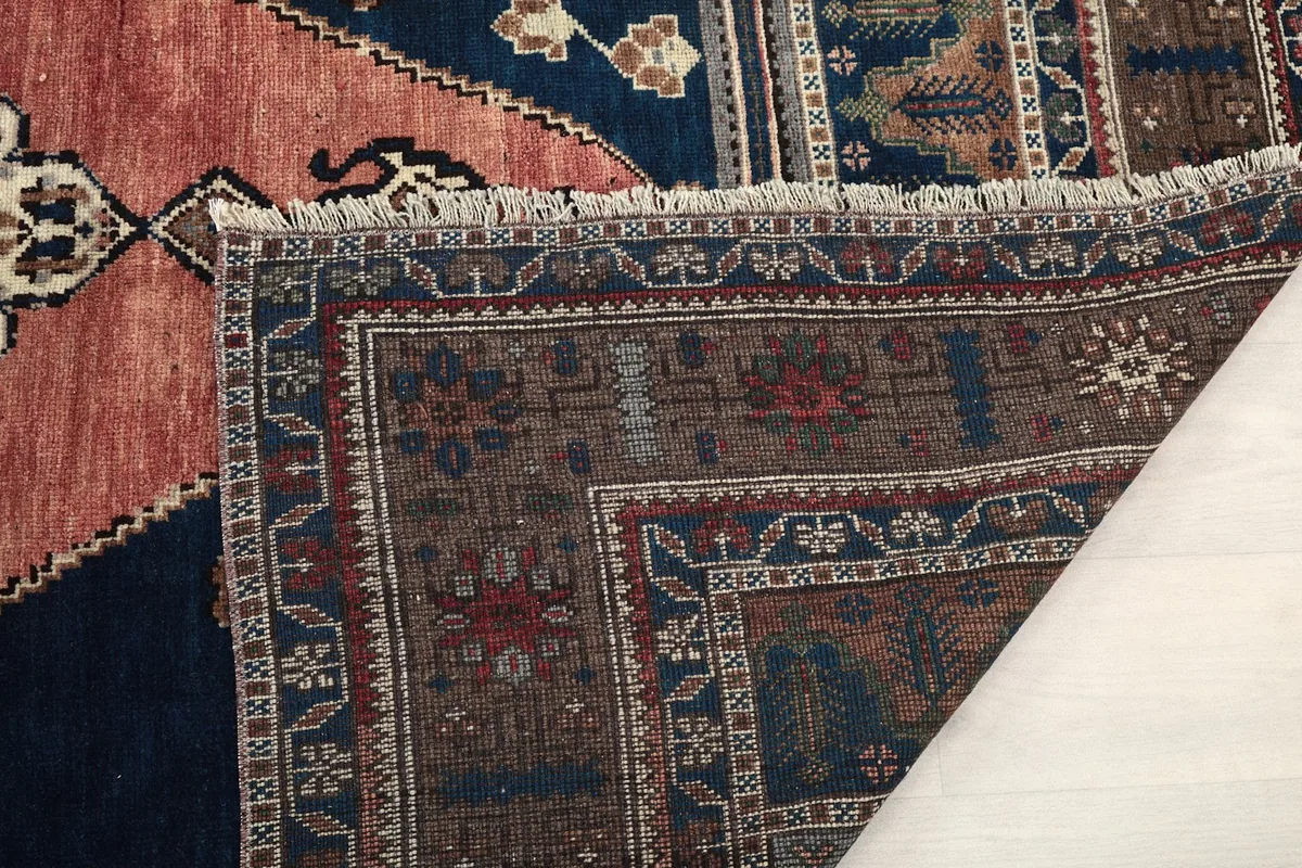 Close-up of the rug's low pile and fringe, with a glimpse of the underside