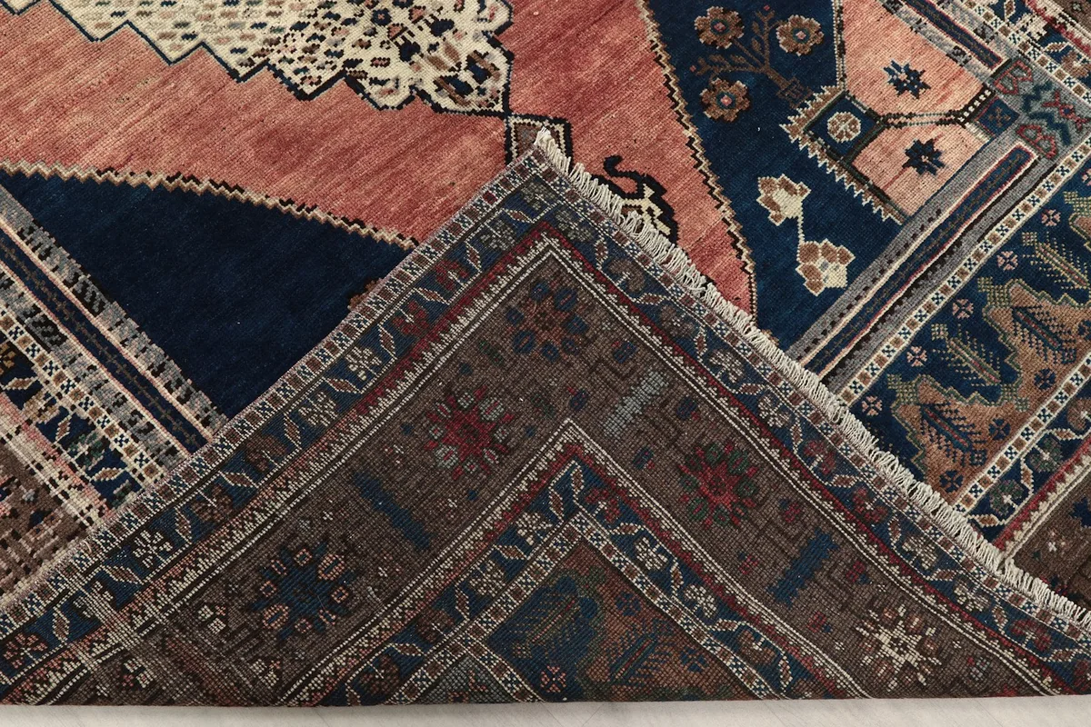 Folded corner of the rug showing the back of the hand-knotted wool pile and cotton foundation