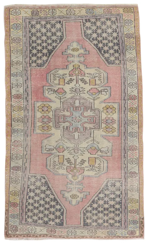 Full overhead view of a rose vintage Anatolian rug with a geometric medallion and border