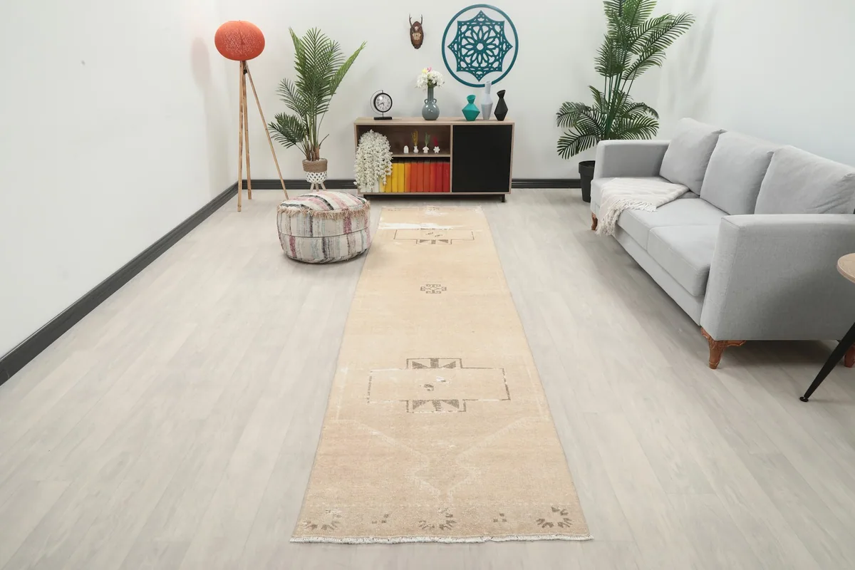 Vintage beige and brown runner rug in a modern living room setting, showcasing its length and pattern