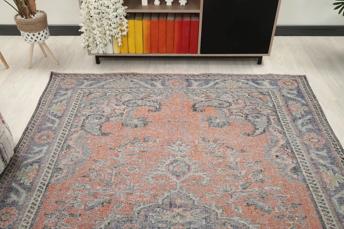 View of the rug in a room, highlighting the upper half of the design near a console.