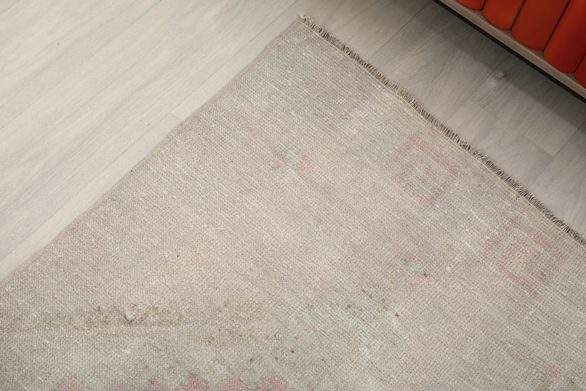 Overhead angled view of one end of the runner, showing the fringe and faded surface