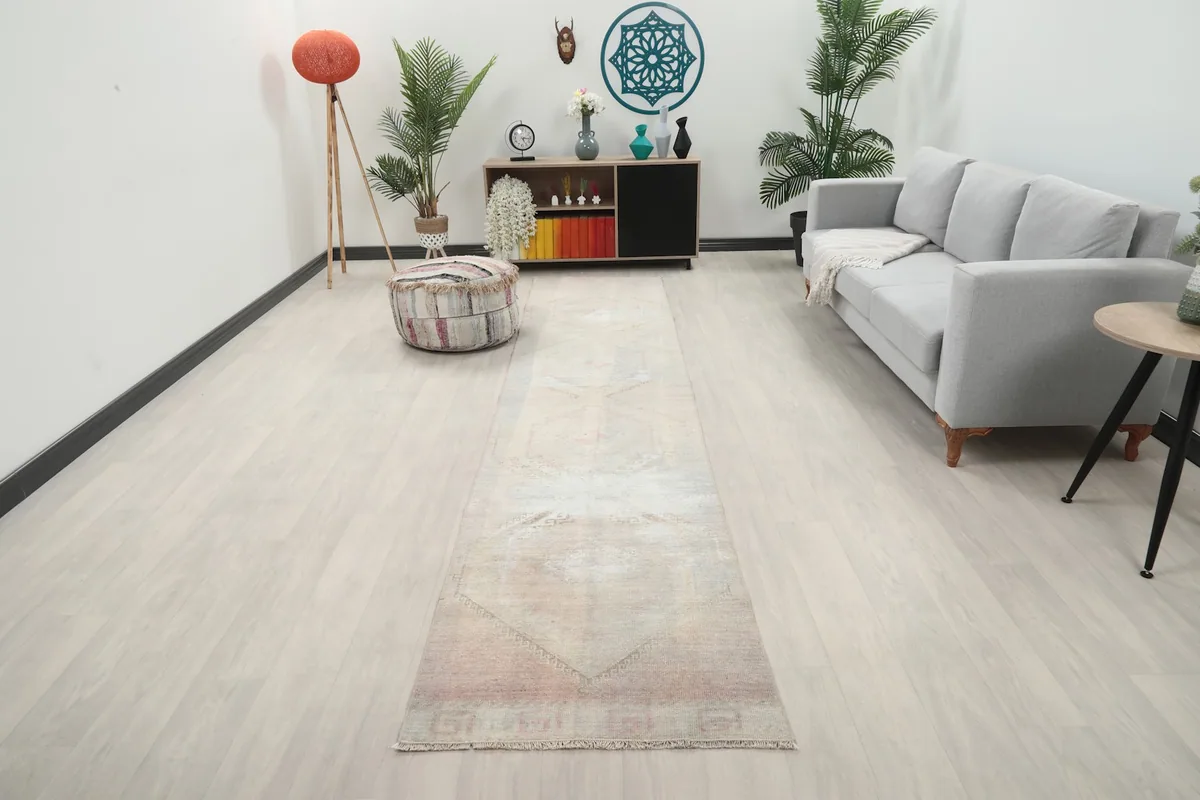 Vintage Anatolian runner rug displayed in a living room setting, showing its length and scale