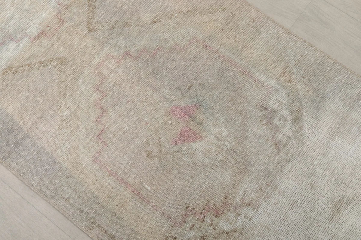 Close-up of a central geometric motif on the runner, showing wear and color variation