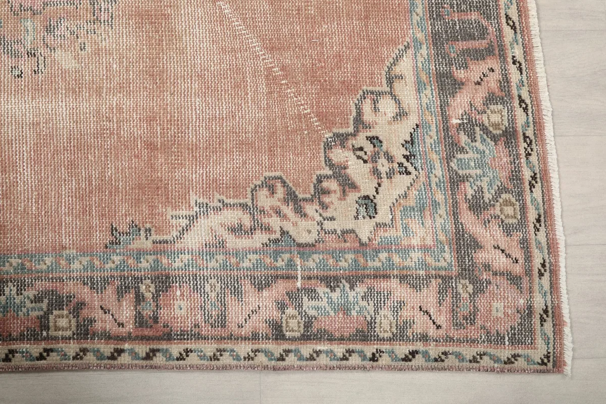 Detailed view of the rug's gray and beige border with floral motifs.