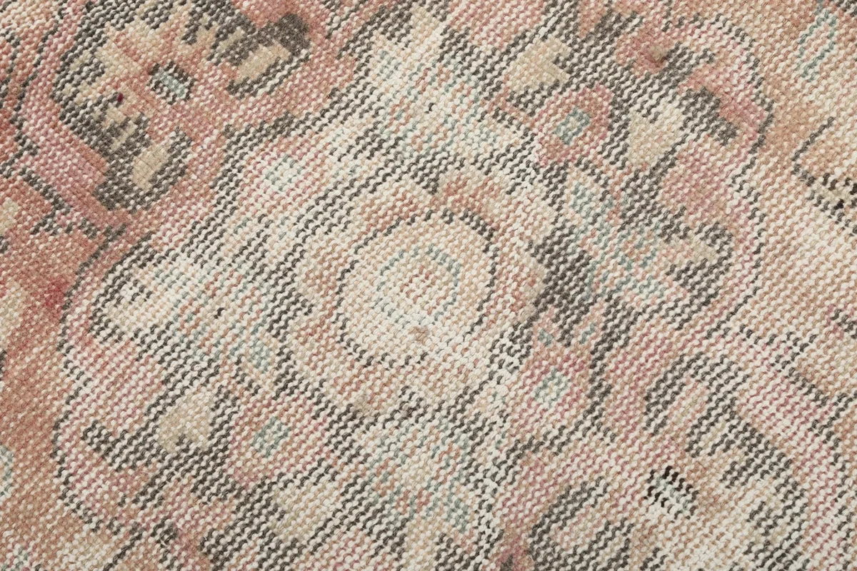 Extreme close-up showing the low wool pile and intricate knotting of the rug.