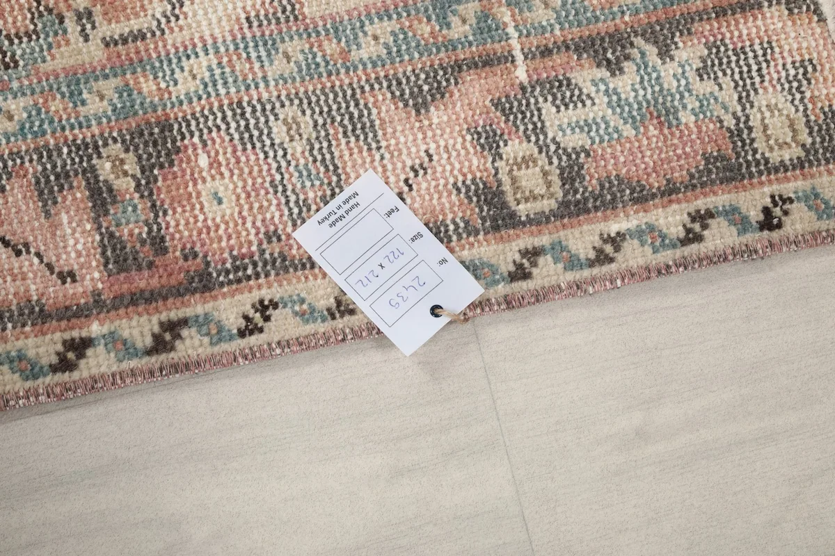 Close-up of the rug's edge with a product tag, showing the wool pile texture.