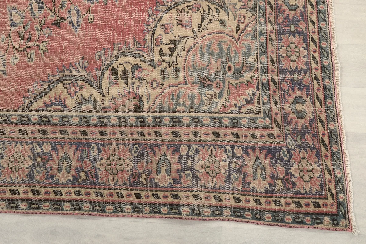 Detail of the blue and ivory border design of the hand-knotted rug