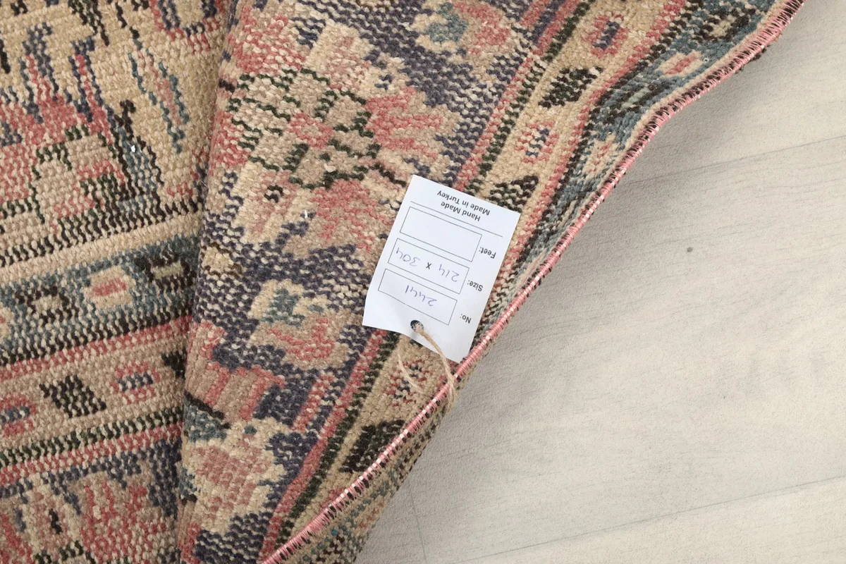 View of the rug's reverse side with a tag indicating its origins and material