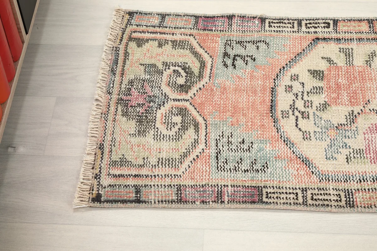Angled view of the rug's top edge, showcasing the distressed pile and color blend.