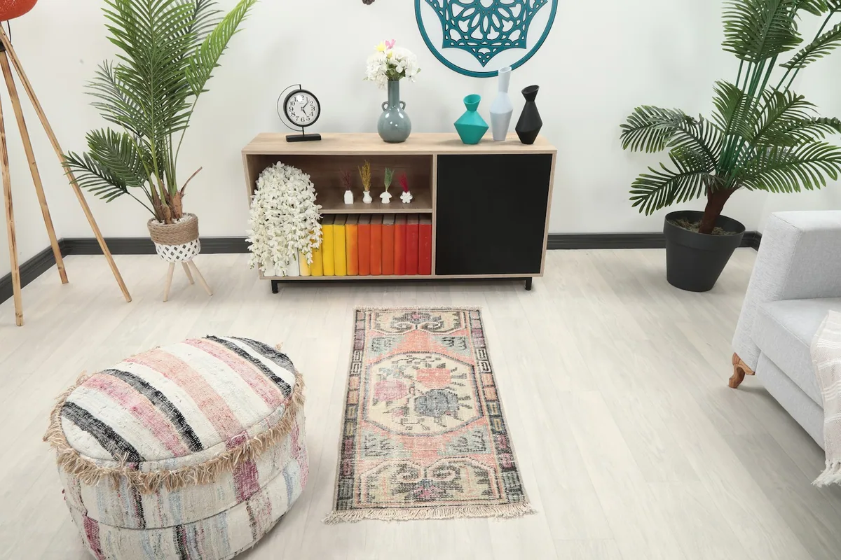 Vintage Anatolian rug displayed in a room setting with a light wood floor and modern furniture.