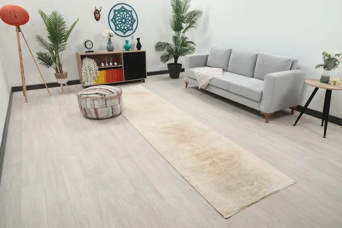 Angled view of the beige runner rug extending through a living space, showing its length.