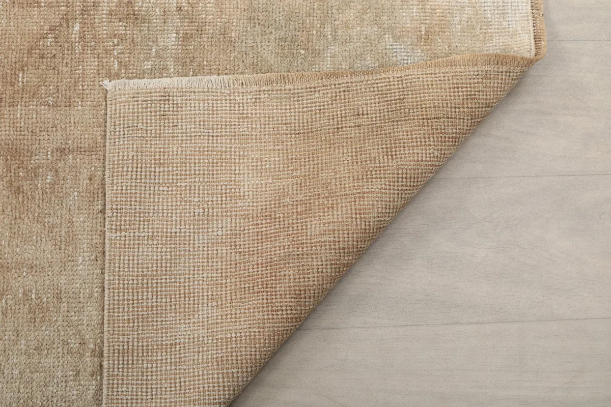 Close-up of the rug's underside, showcasing the tight weave of the cotton foundation.