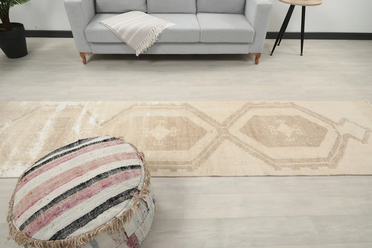 Runner rug in a room with a sofa and ottoman, showcasing its length