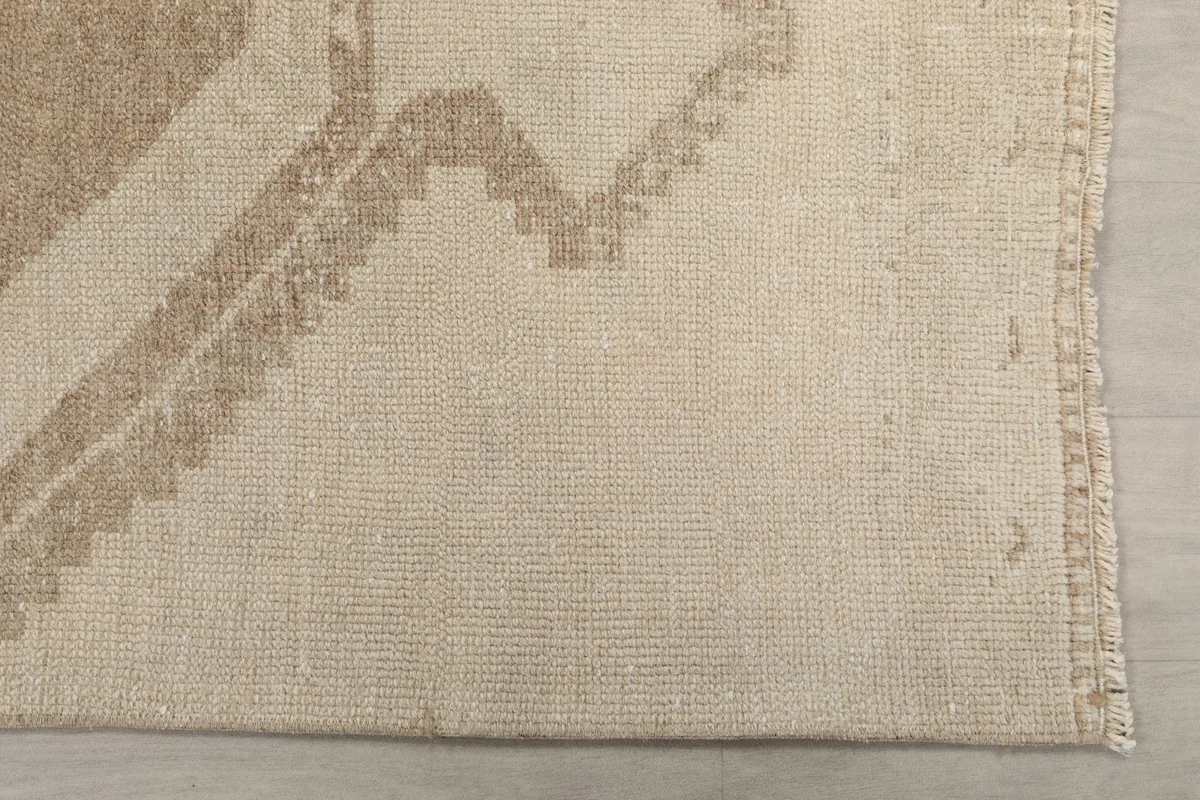 Detailed view of the rug's edge and the subtle beige color variations