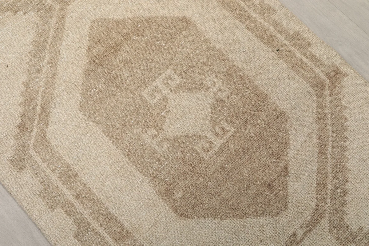 Close-up of a central geometric motif in brown on the beige runner
