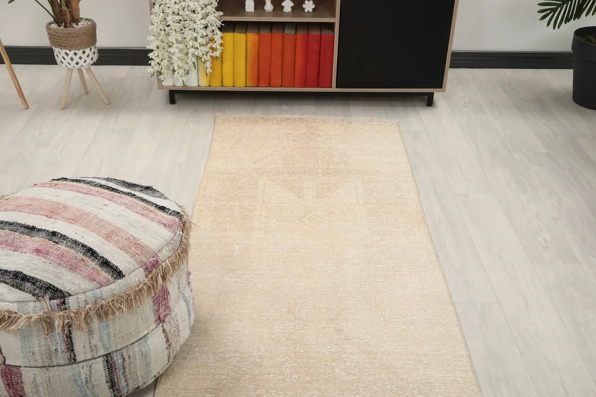 Runner rug extending from an ottoman towards a console table