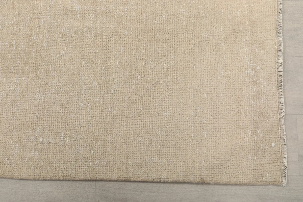 Detailed view of the low pile and subtle texture of the beige rug