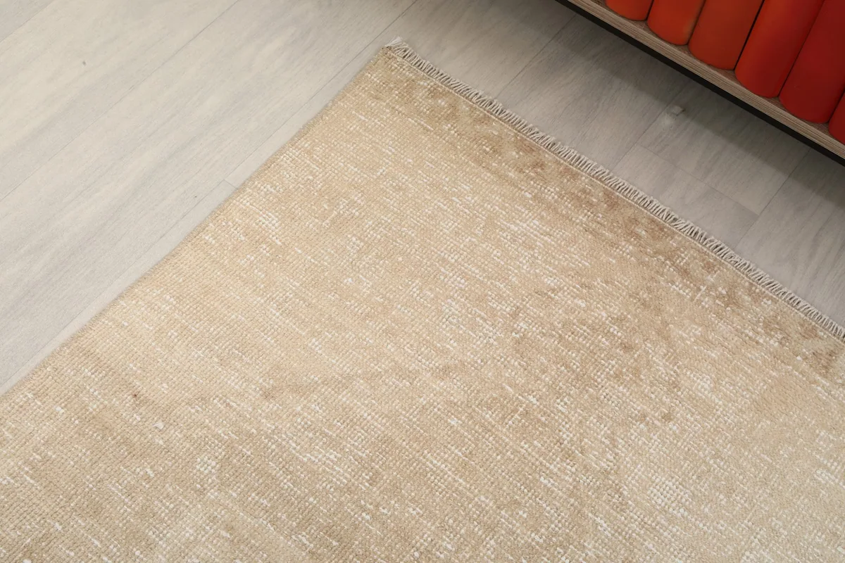 Corner detail of the beige runner rug showing the subtle edge and color variations