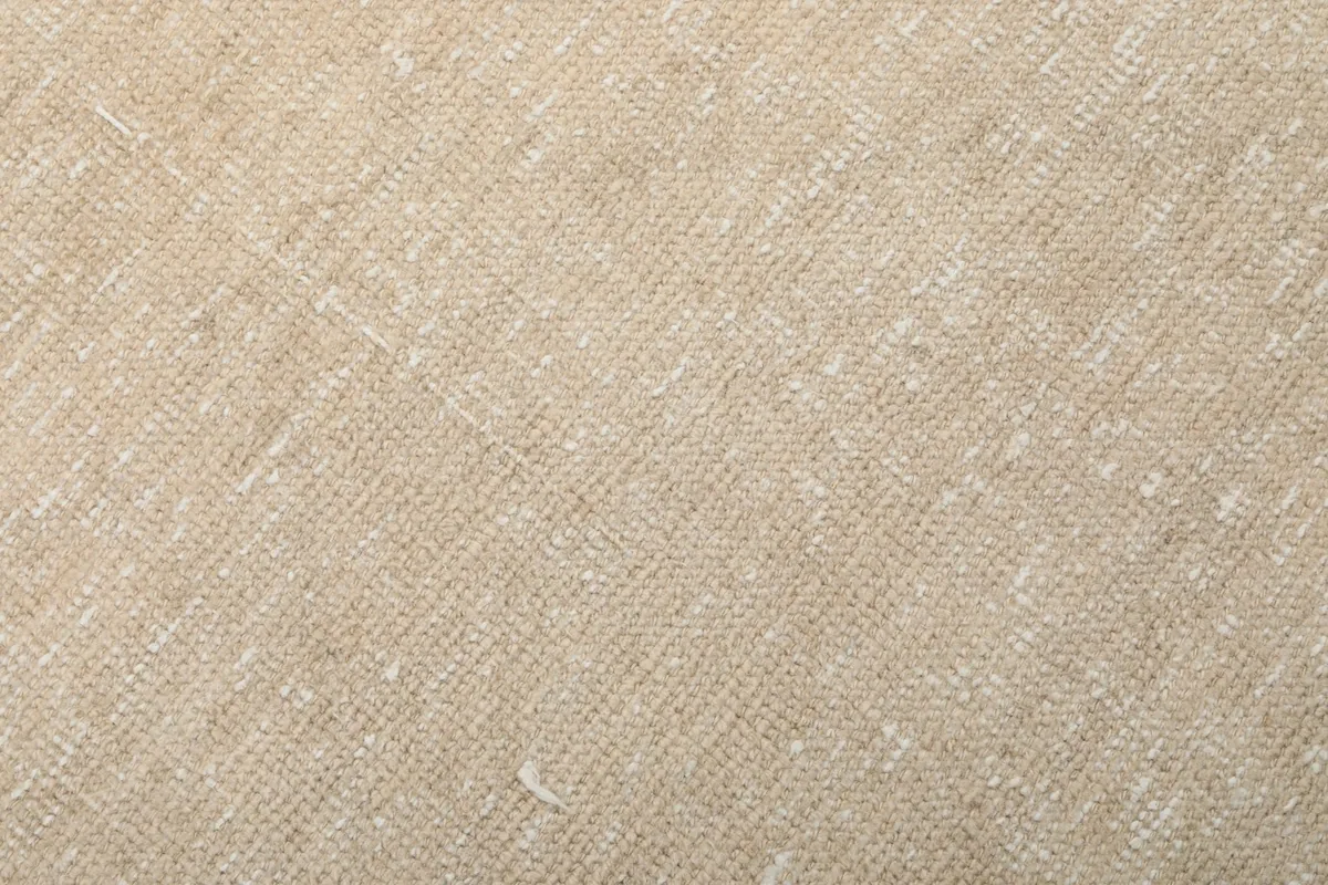 Close-up texture of the hand-knotted wool pile on the beige rug