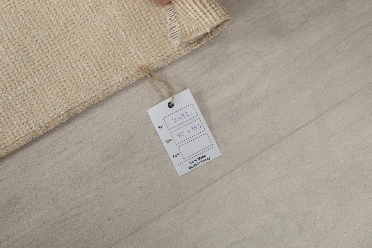 Product tag attached to the rug, showing 'Hand Made in Turkey' and size details