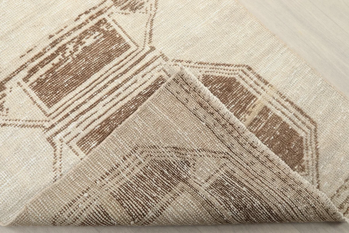 Corner fold revealing the wool pile and cotton foundation of the vintage rug