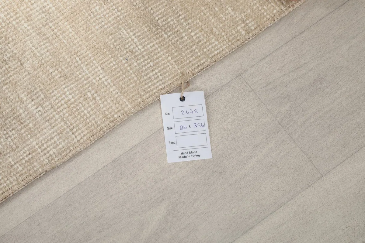 Close-up of the rug with a product tag displaying size and origin information.