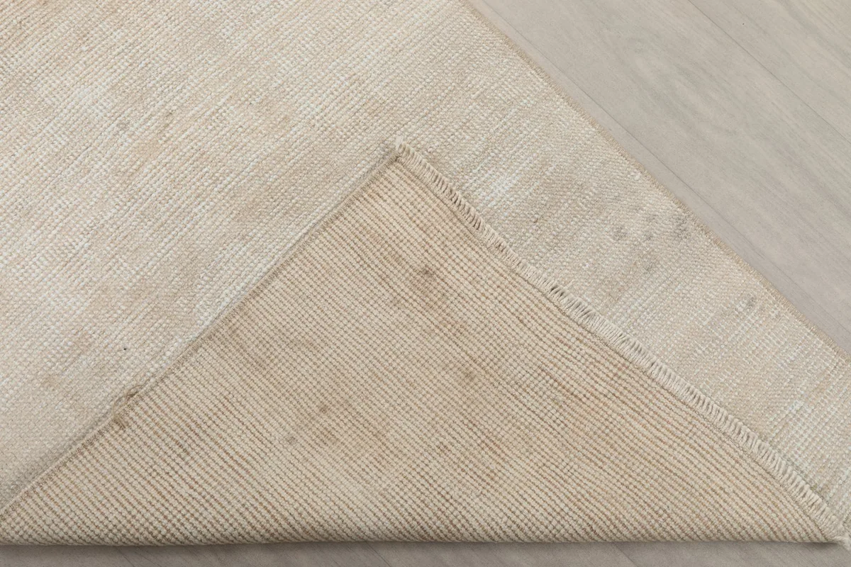 Underside corner of the rug, revealing the cotton foundation and hand-knotting