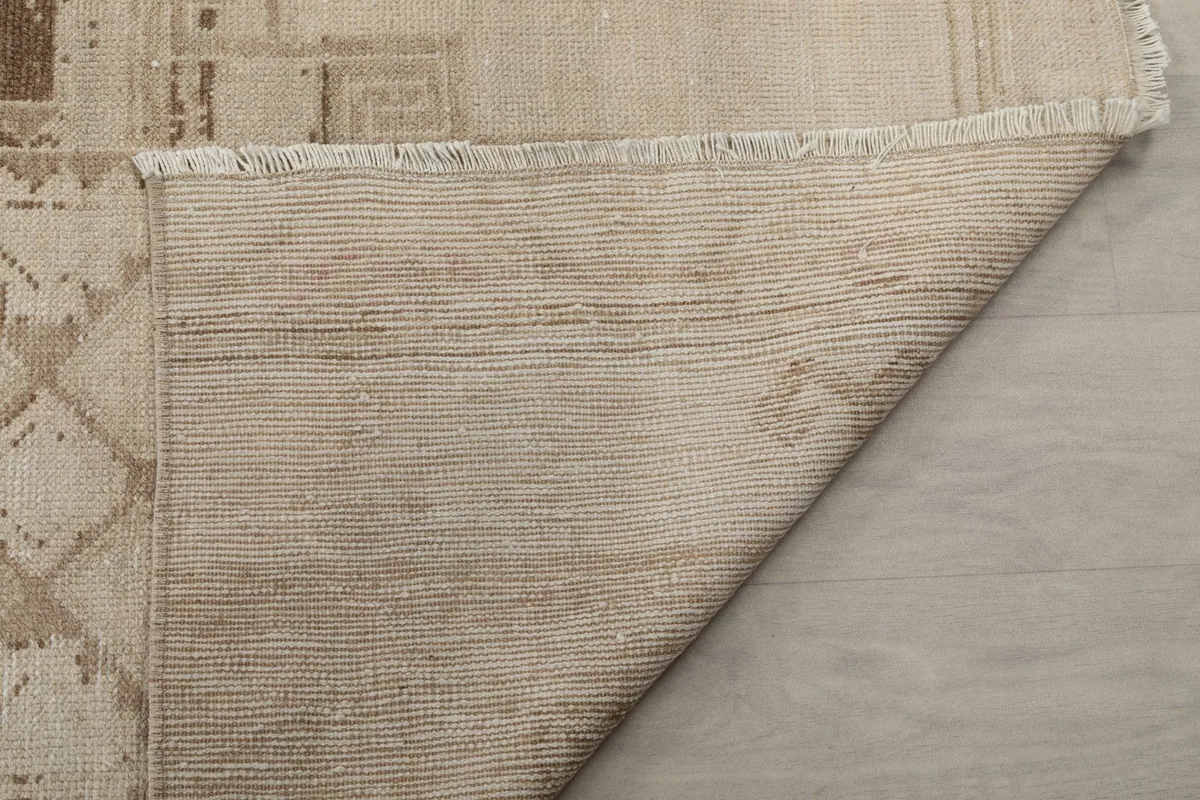Another view of the rug's back, showing the consistent weave of the cotton foundation
