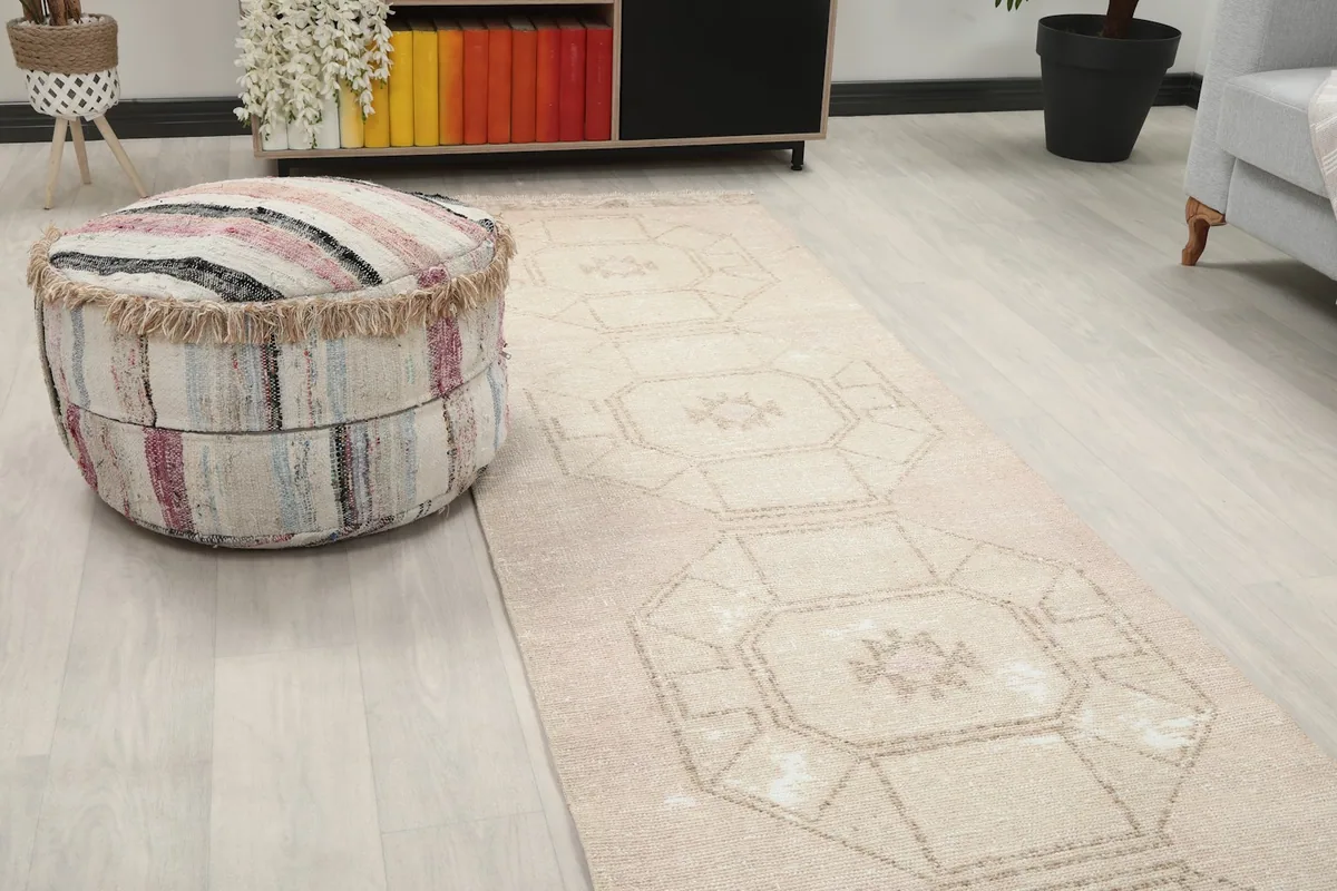 Close-up view of the runner rug's pattern alongside a textured ottoman in a room setting