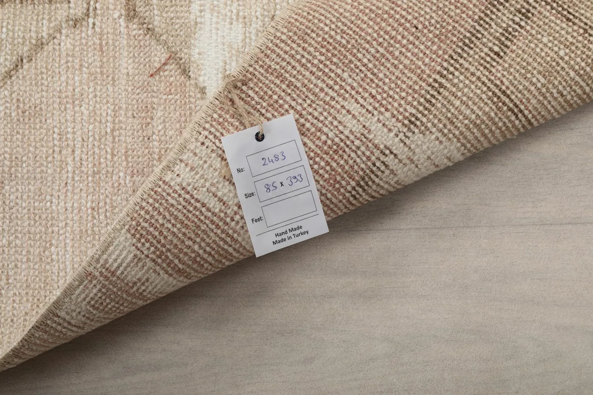 Close-up of the rug's back with a tag, showing the hand-knotted structure and material