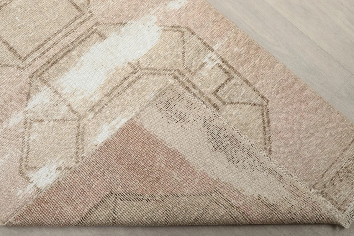Folded corner of the rug revealing the cotton foundation and reverse side