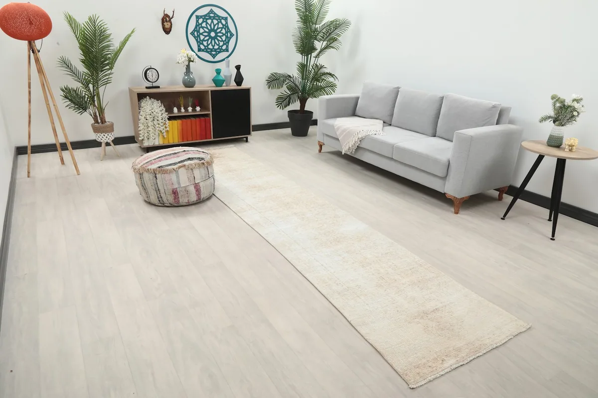 Angled view of the cream runner rug in a room, showing its length and neutral tones