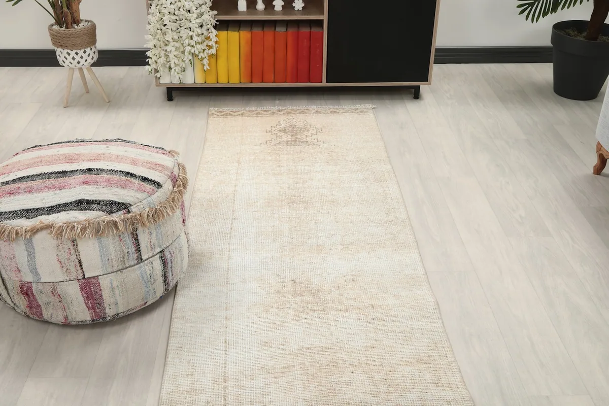 View of the rug's far end in a room setting, highlighting a subtle geometric motif