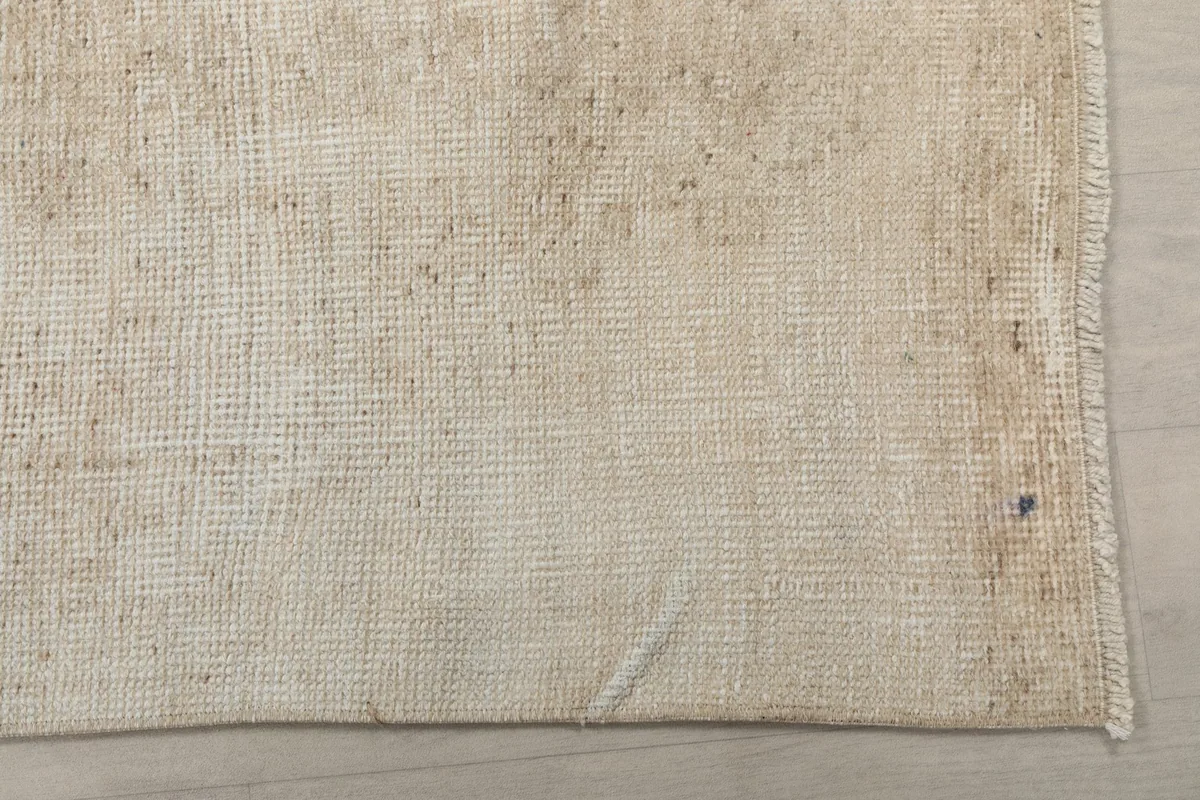 Close-up of the rug's surface, showing the distressed wool pile and cotton foundation