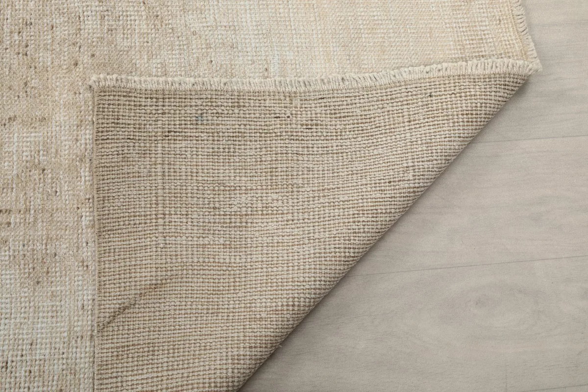 Another view of the rug's underside, showcasing the tight weave of the cotton foundation