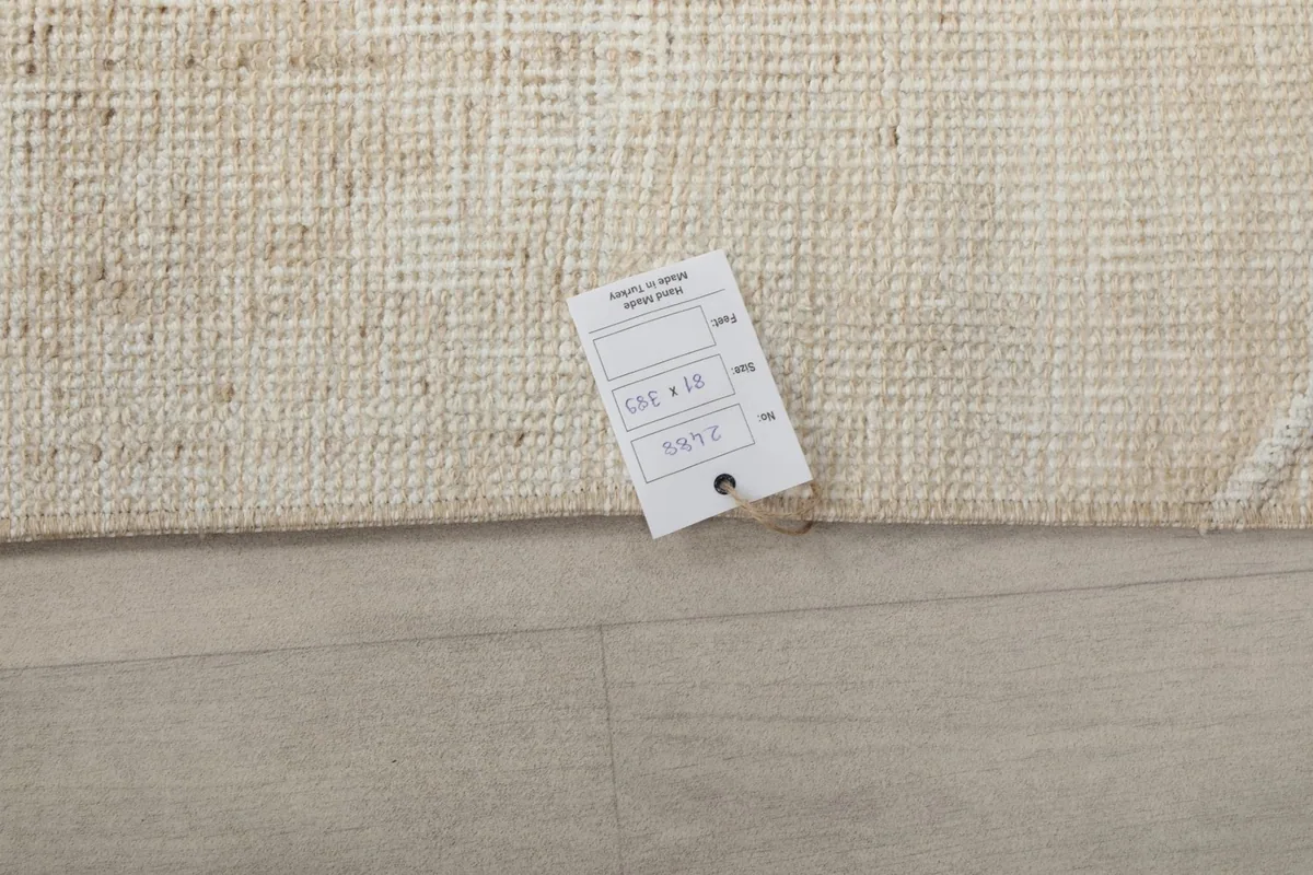Close-up of the rug's corner with a tag showing product details and dimensions